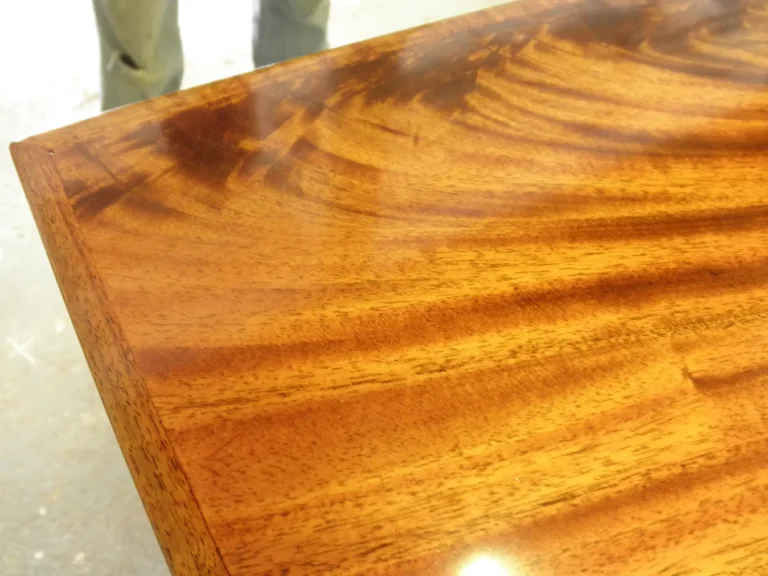 Dining table with chandelier damage during repair and piano finish refinishing by Olek Inc.